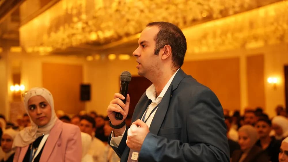 An attendee shares a question with the room